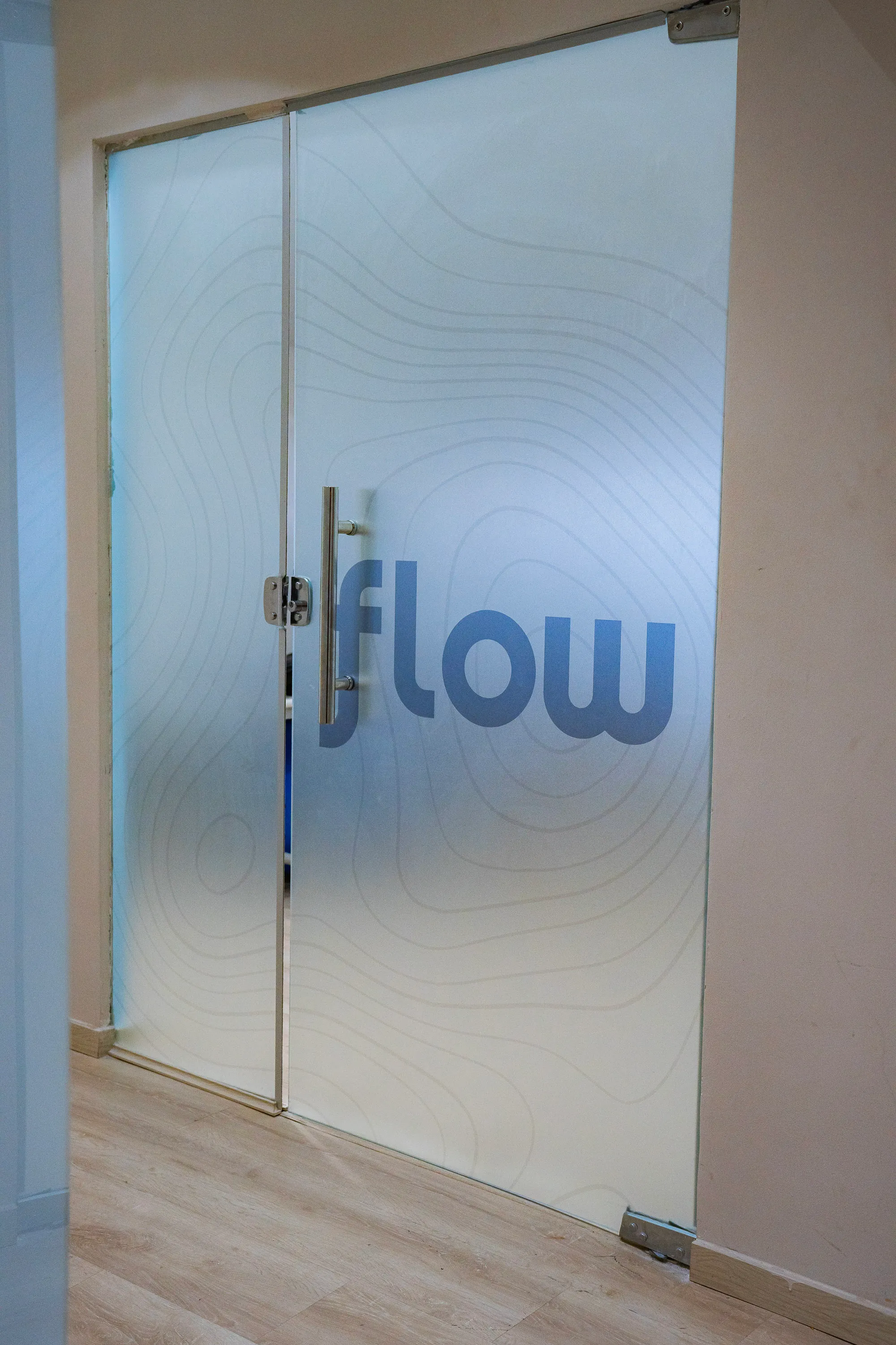 Porta de entrada do estúdio da Flow, com a logo gravada no vidro